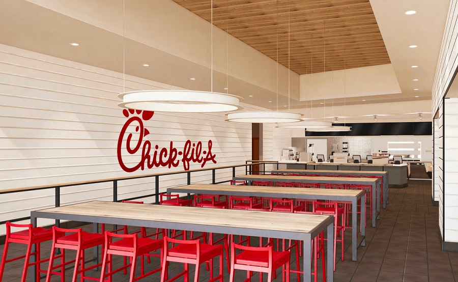 Interior of Chick-fil-A restaurant with red seating and wooden tables.