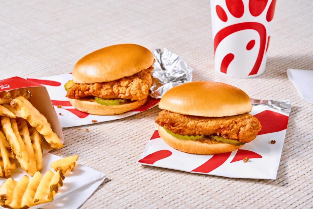 Two Chick-fil-A Chicken sandwiches with waffle fries and a drink