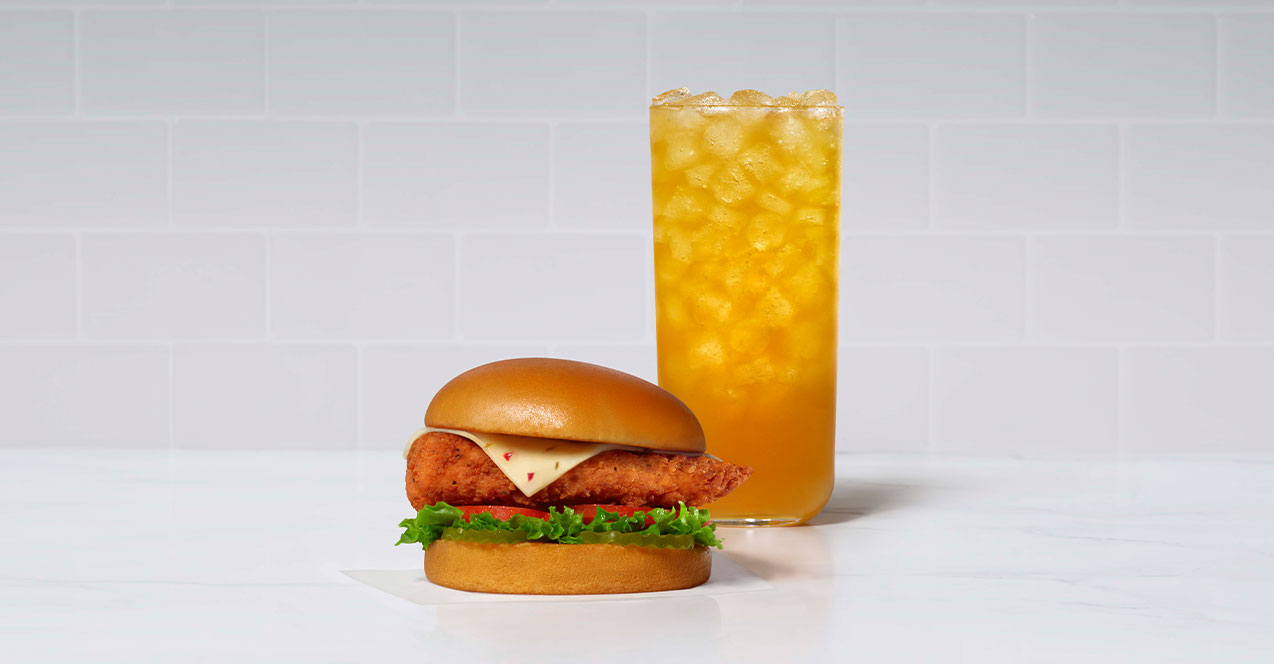 A glass of Mango Passion Sunjoy and the Spicy Deluxe Sandwich.
