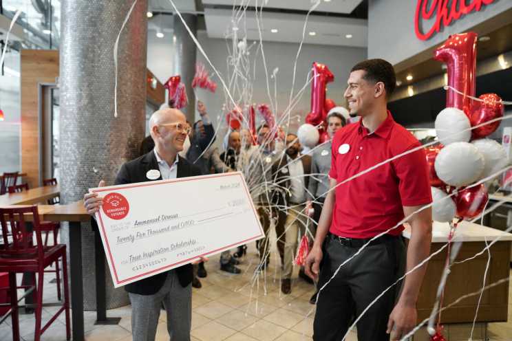 Andrew T. Cathy, CEO of Chick-fil-A, Inc presenting an over-sized check to a team member.