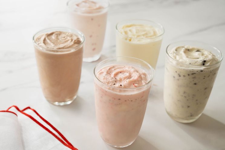 Five different varieties of milkshakes in glasses.