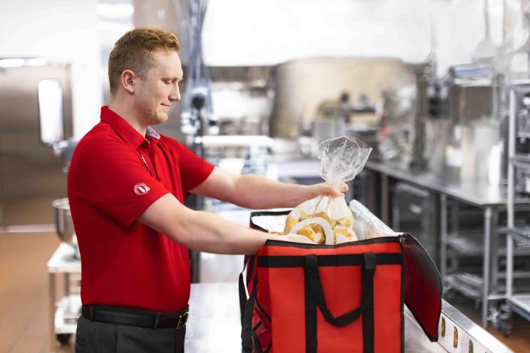 A Chick-fil-A team member packs an insulated bag for a Shared Table donation.