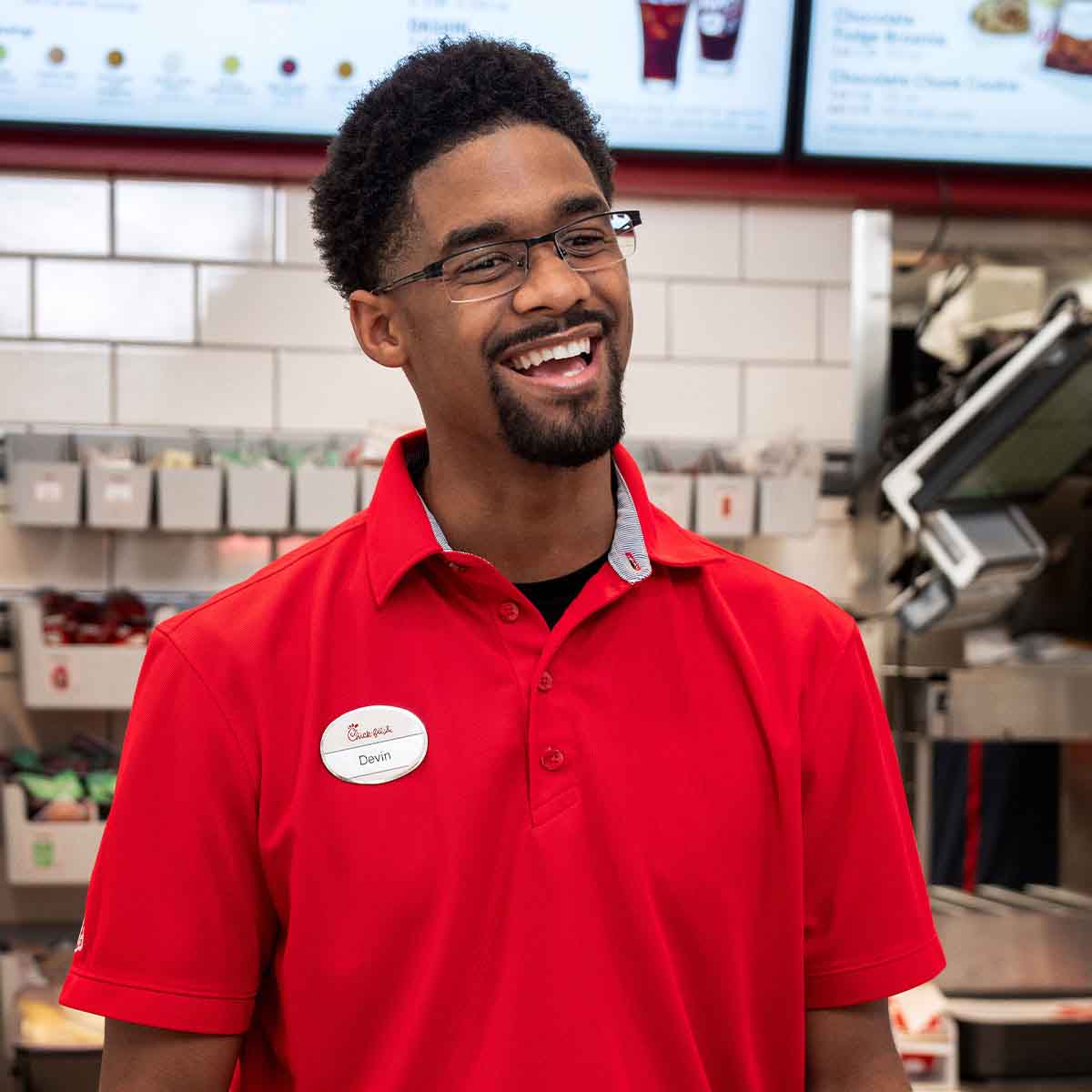 A male Team Member standing at a counter and smiling