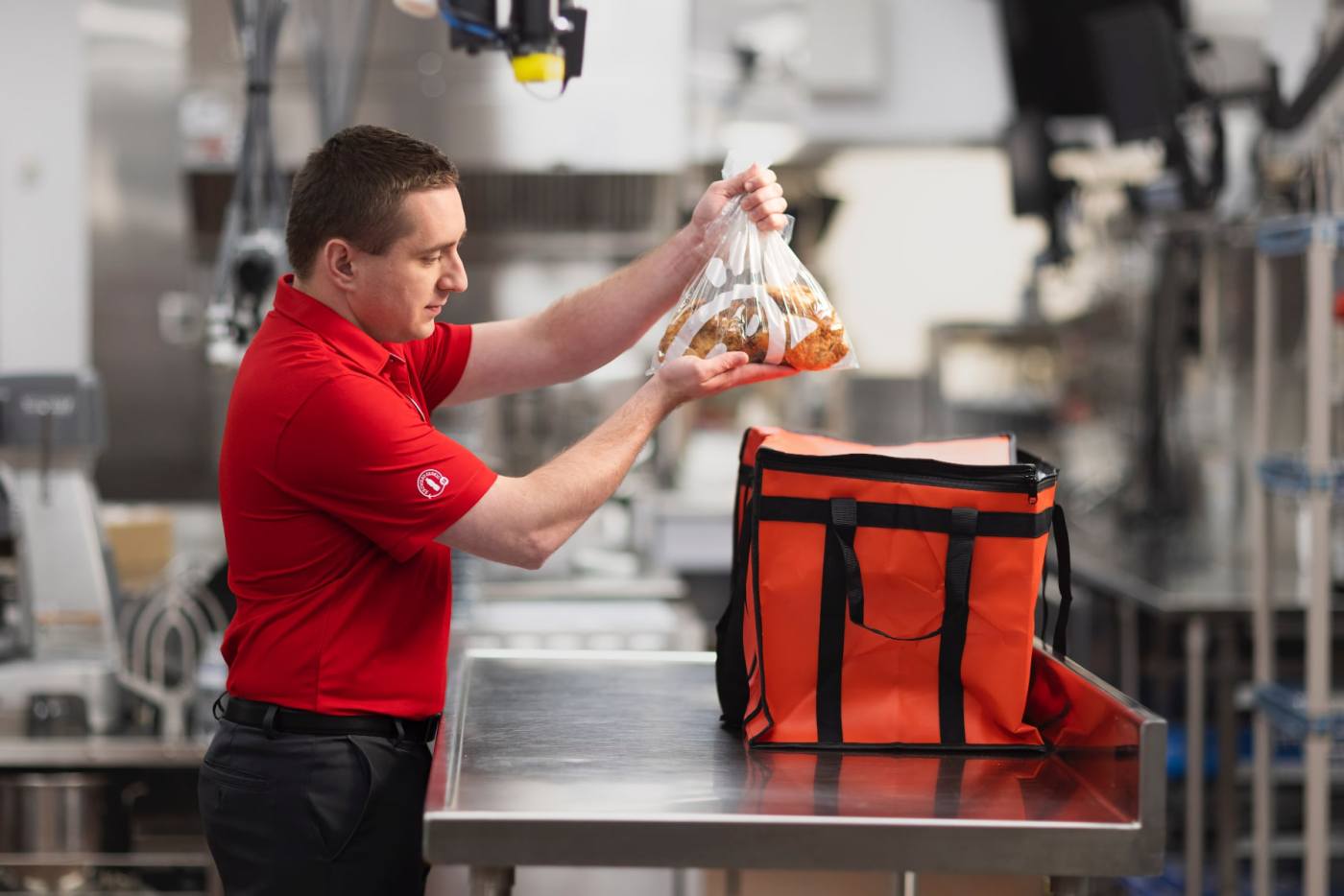 Team member packing chicken into an insulated bag.