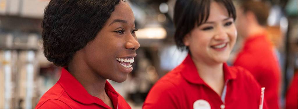 Two team members smiling at Chick-fil-A counter.
