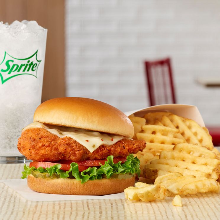 Spicy Deluxe Sandwich with waffle fries and a glass of Sprite.