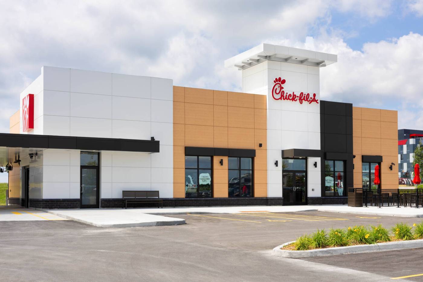 Modern Chick-fil-A restaurant building with drive-thru and outdoor seating.