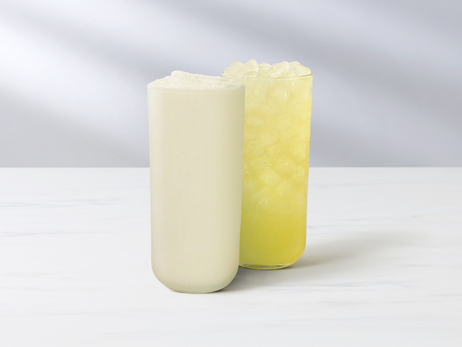 A glass of Key Lime Lemonade and a glass of frozen Key Lime Lemonade with a sliced fresh key lime.