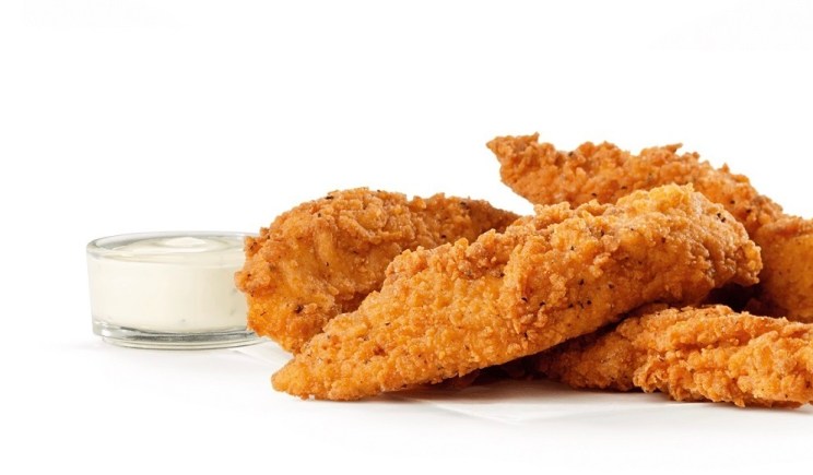 Spicy Chick-n-Strips with a small glass bowl of dipping sauce.