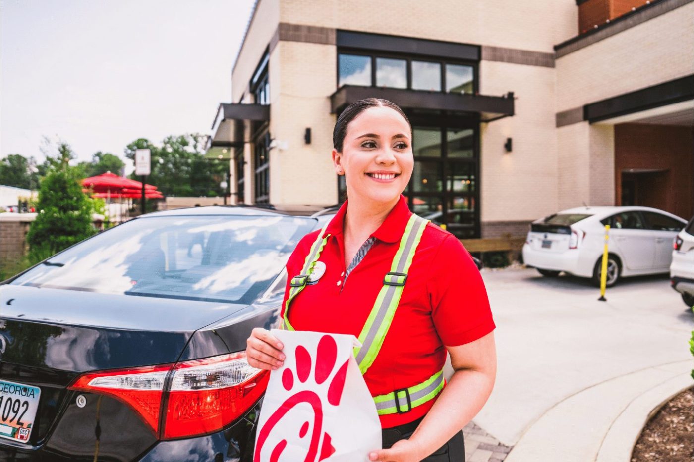 Smiling team member bringing food to drive-thru customers.