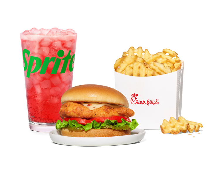 Spicy Deluxe Sandwich on a white plate with Waffle Fries and a Strawberry Hibiscus & Sprite®