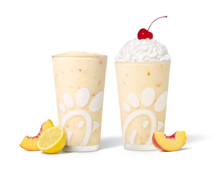Peach Frosted Lemonade with a lemon half and a peach slice next to a Peach Milkshake with a peach slice