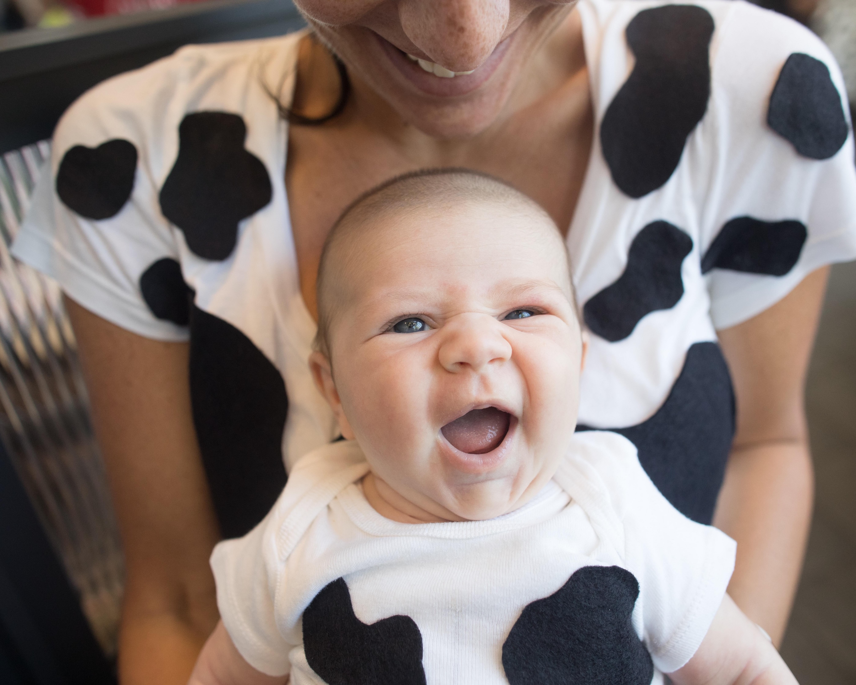 Baby smiling dressed as a Chick-fil-A Cow.