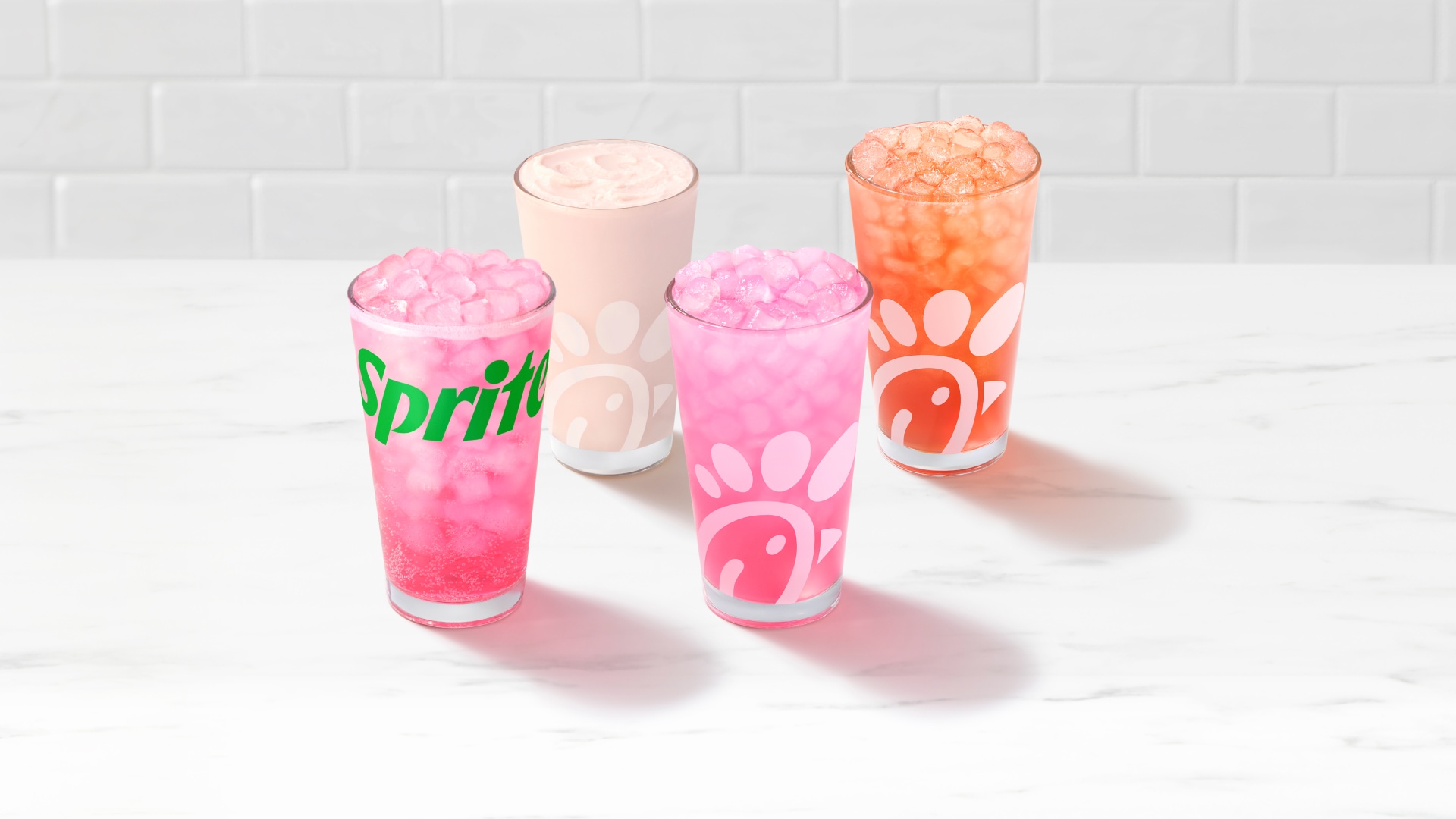 Glasses of Pineapple Dragonfruit & Sprite®, Frosted, Lemonade, or Sunjoy® on a white tiled background